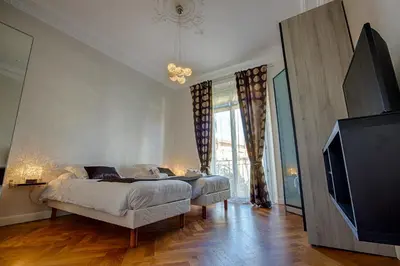 a bedroom with a bed and a flat screen tv at Appartement Vaste Horizon - LRA Cannes in Cannes