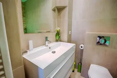a bathroom with a white sink and a toilet at Appartement Vaste Horizon - LRA Cannes in Cannes