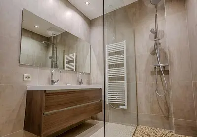 a bathroom with a shower with a sink and a glass shower stall at Appartement Vaste Horizon - LRA Cannes in Cannes