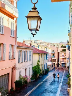 two people walking down a street with a street light at cœur historique de cannes entre palais et mer in Cannes