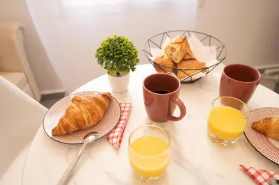 a table with plates of croissants and glasses of orange juice at cœur historique de cannes entre palais et mer in Cannes
