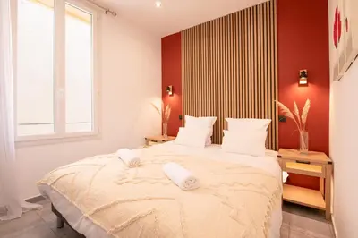 a bedroom with a large bed with two towels on it at cœur historique de cannes entre palais et mer in Cannes