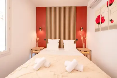 a bedroom with a large bed with two pillows at cœur historique de cannes entre palais et mer in Cannes