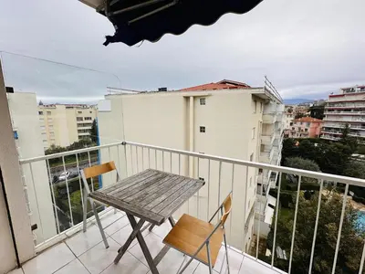 a wooden table and two chairs on a balcony at Two bedroom apartment on a high floor in the center of Cannes a few steps from the Croisette beaches - 2229 in Cannes