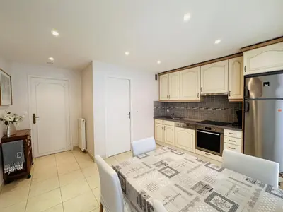 a kitchen with a table with chairs and a refrigerator at Two bedroom apartment on a high floor in the center of Cannes a few steps from the Croisette beaches - 2229 in Cannes