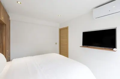 a bedroom with a white bed and a flat screen tv at Carlton area superb 1 bedroom in Cannes
