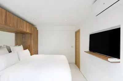 a bedroom with a white bed and a flat screen tv at Carlton area superb 1 bedroom in Cannes