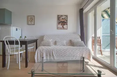 a bedroom with a bed with a blue blanket and a window at FRGK Fauvettes Apartment Terrace, Parking, AC & Ultra-Fast Wi-Fi in Cannes