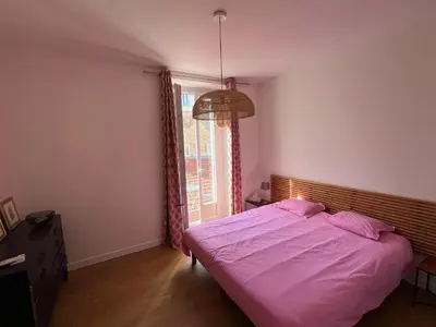 a bedroom with a large bed and a window at Viva Riviera - 10 Rue Florian in Cannes