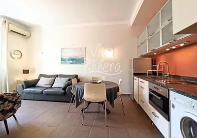 a kitchen and living room with a table and a couch at Viva Riviera - 10 Rue Florian in Cannes
