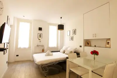 a white room with a bed and a table at Magnifique T2 au cœur de Cannes in Cannes