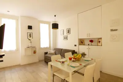a white living room with a table and chairs at Magnifique T2 au cœur de Cannes in Cannes