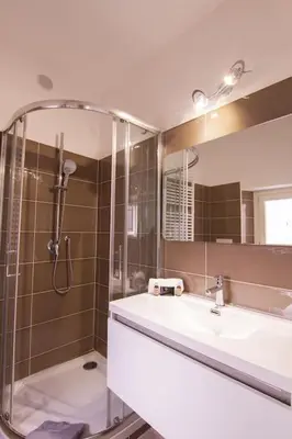 a bathroom with a shower and a sink and a mirror at Magnifique T2 au cœur de Cannes in Cannes