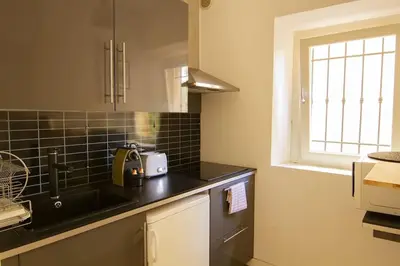 a kitchen with a black counter top and a window at Magnifique T2 au cœur de Cannes in Cannes