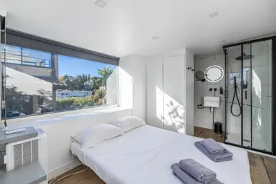 a white bedroom with a bed and a large window at New! Villa de luxe centre Cannes in Cannes
