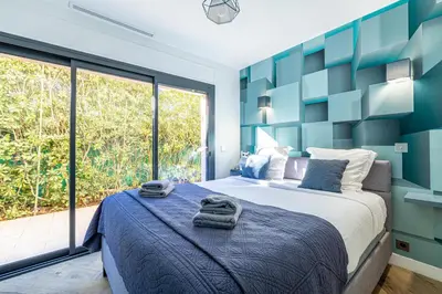 a bedroom with a large bed and a large window at New! Villa de luxe centre Cannes in Cannes