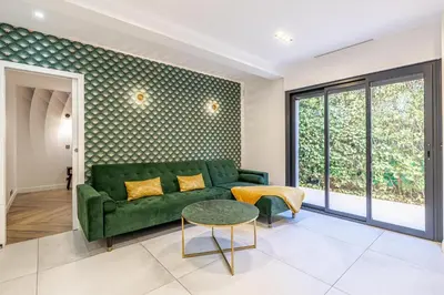 a living room with a green couch and a table at New! Villa de luxe centre Cannes in Cannes