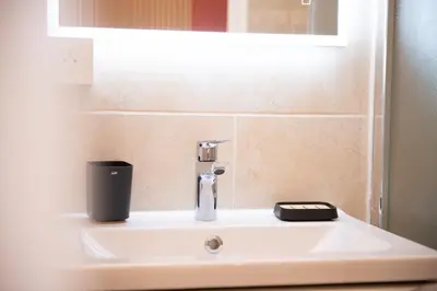 a sink with a faucet and a cell phone on it at le suquet entre palais et des plages in Cannes