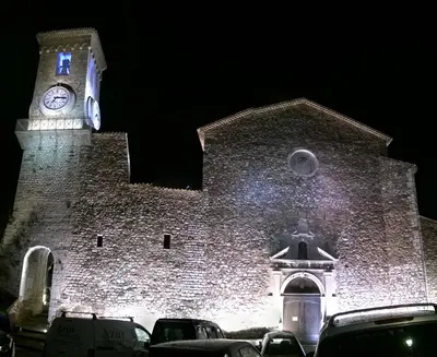 a large brick building with a clock tower at night at le suquet entre palais et des plages in Cannes