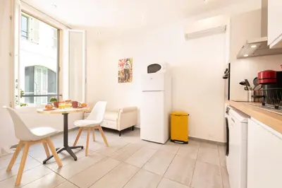 a kitchen and dining room with a table and a refrigerator at le suquet entre palais et des plages in Cannes