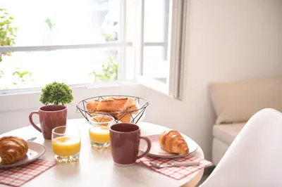 a table with a breakfast of croissants and orange juice at le suquet entre palais et des plages in Cannes