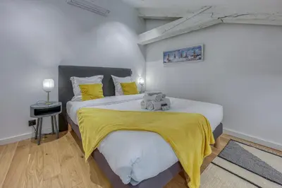 a bedroom with a large bed with a yellow blanket at Loft Croisette Standing Presta in Cannes