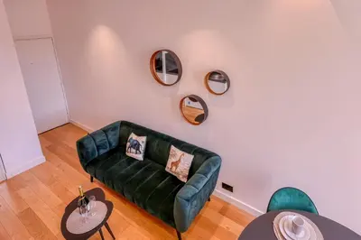 a living room with a green couch and two tables at Loft Croisette Standing Presta in Cannes
