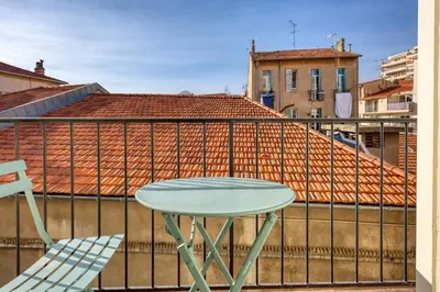a table and chair on a balcony with a roof at Loft Croisette Standing Presta in Cannes