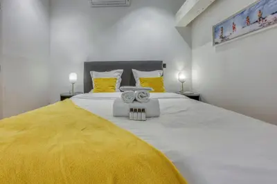 a bedroom with a large bed with a yellow blanket at Loft Croisette Standing Presta in Cannes