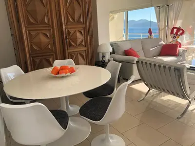 a living room with a white table and chairs at Coeur de Cannes in Cannes