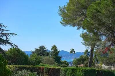 a garden with a view of the water and mountains at Cannes, splendide villa dans un domaine privé in Le Cannet