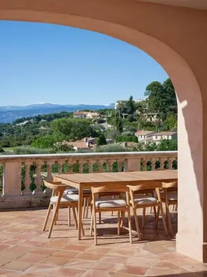 a wooden table and chairs sitting on a patio at Cannes, splendide villa dans un domaine privé in Le Cannet
