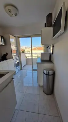 a large white kitchen with a washer and dryer at Cannes SEASIDE BEACHFRONT bord de mer in Cannes