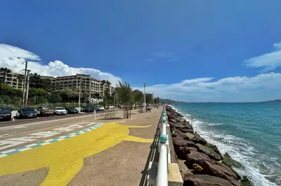 a sidewalk next to the ocean with cars parked at Le Seaview-Quiet-Swimming pool-Car park-Seafront in Cannes