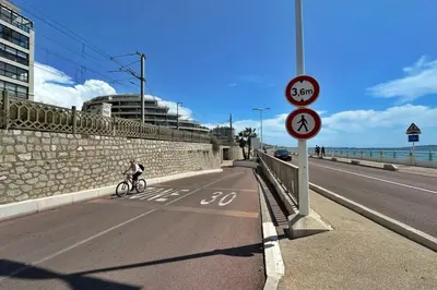 a person riding a bike down a road with a speed sign at Le Seaview-Quiet-Swimming pool-Car park-Seafront in Cannes