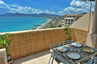 a table on a balcony with a view of the ocean at Le Seaview-Quiet-Swimming pool-Car park-Seafront in Cannes