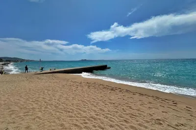a sandy beach with a pier in the ocean at Le Seaview-Quiet-Swimming pool-Car park-Seafront in Cannes