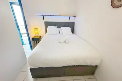 a bedroom with a bed with white sheets and pillows at Le Seaview-Quiet-Swimming pool-Car park-Seafront in Cannes