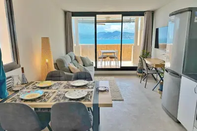 a kitchen and living room with a table and a refrigerator at Le Seaview-Quiet-Swimming pool-Car park-Seafront in Cannes