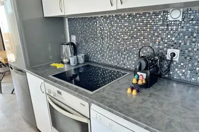 a kitchen counter with a sink and a refrigerator at Le Seaview-Quiet-Swimming pool-Car park-Seafront in Cannes