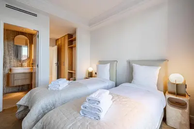 two beds in a room with a bathroom at 1974 - Luxurious 3 bedrooms - Sea view & Parking in Cannes