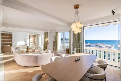 a living room with a table and chairs and the ocean at 1974 - Luxurious 3 bedrooms - Sea view & Parking in Cannes