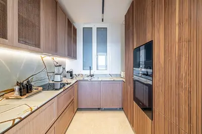 a large kitchen with wooden cabinets and a television at 1974 - Luxurious 3 bedrooms - Sea view & Parking in Cannes