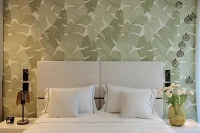 a bedroom with a white bed with a floral wall at 1973 - Luxurious waterfront apartment Croisette in Cannes