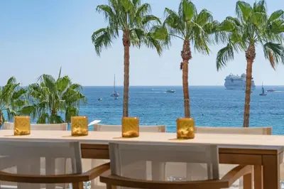 a table with chairs and a view of the ocean at 1973 - Luxurious waterfront apartment Croisette in Cannes