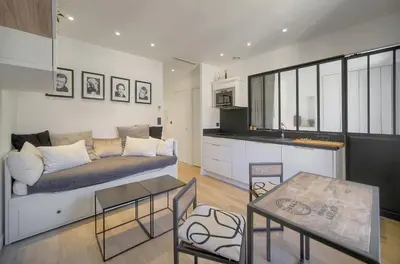 a living room with a couch and a kitchen at Le Nico - Elégant - Centre - VCA in Cannes