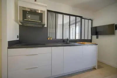 a white kitchen with a sink and a microwave at Le Nico - Elégant - Centre - VCA in Cannes