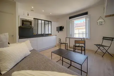 a living room with a bed and a table and chairs at Le Nico - Elégant - Centre - VCA in Cannes