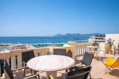 a balcony with a table and chairs and the ocean at Cannes - Roof terrace for rent in Cannes