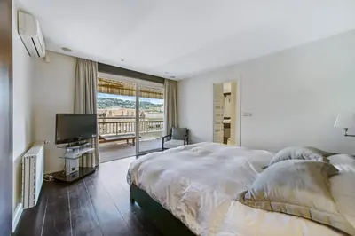 a bedroom with a large bed and a television at REF 1319 - Cannes Center - Apartment for rent in Cannes